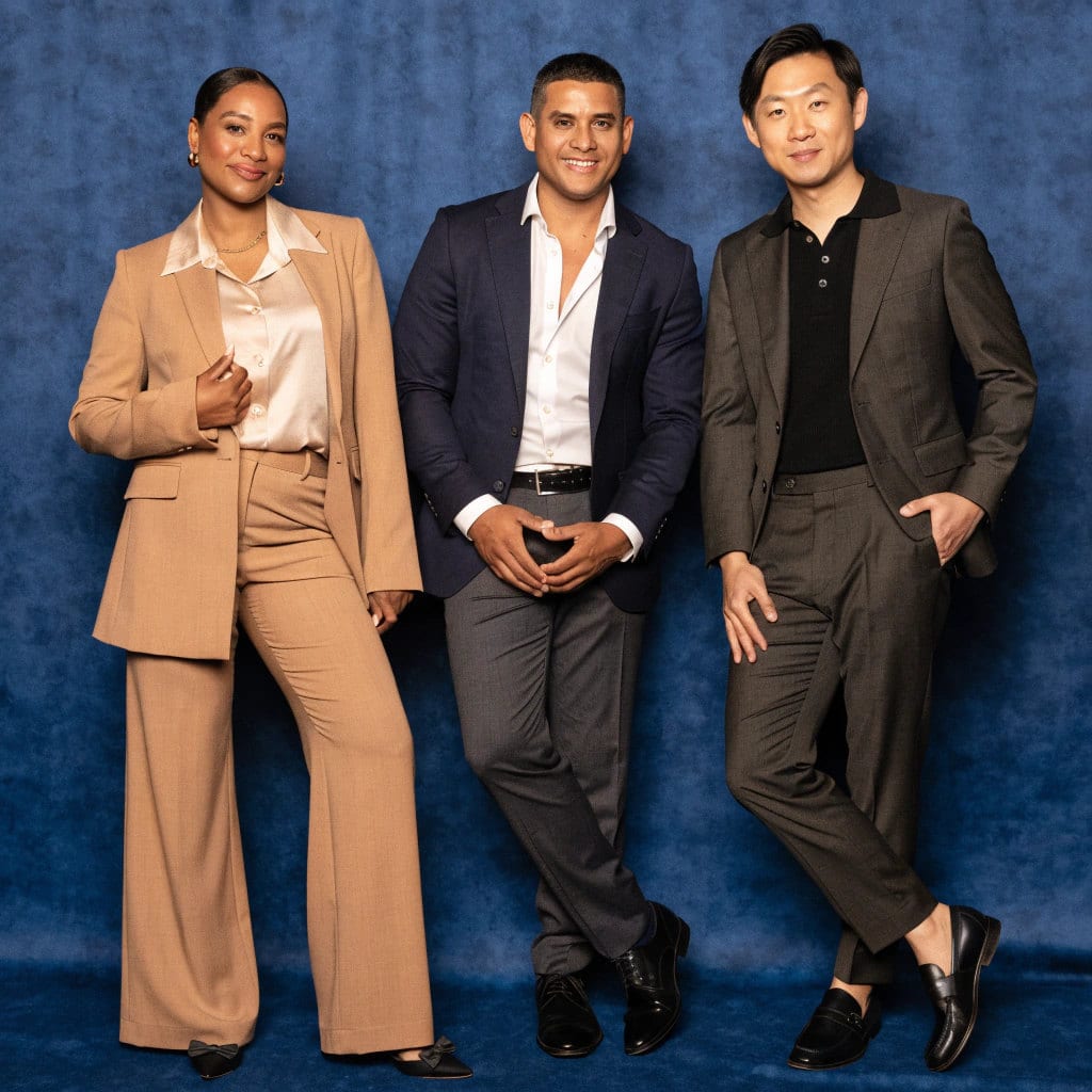 Colleagues in suits against a deep blue backdrop at a company event
