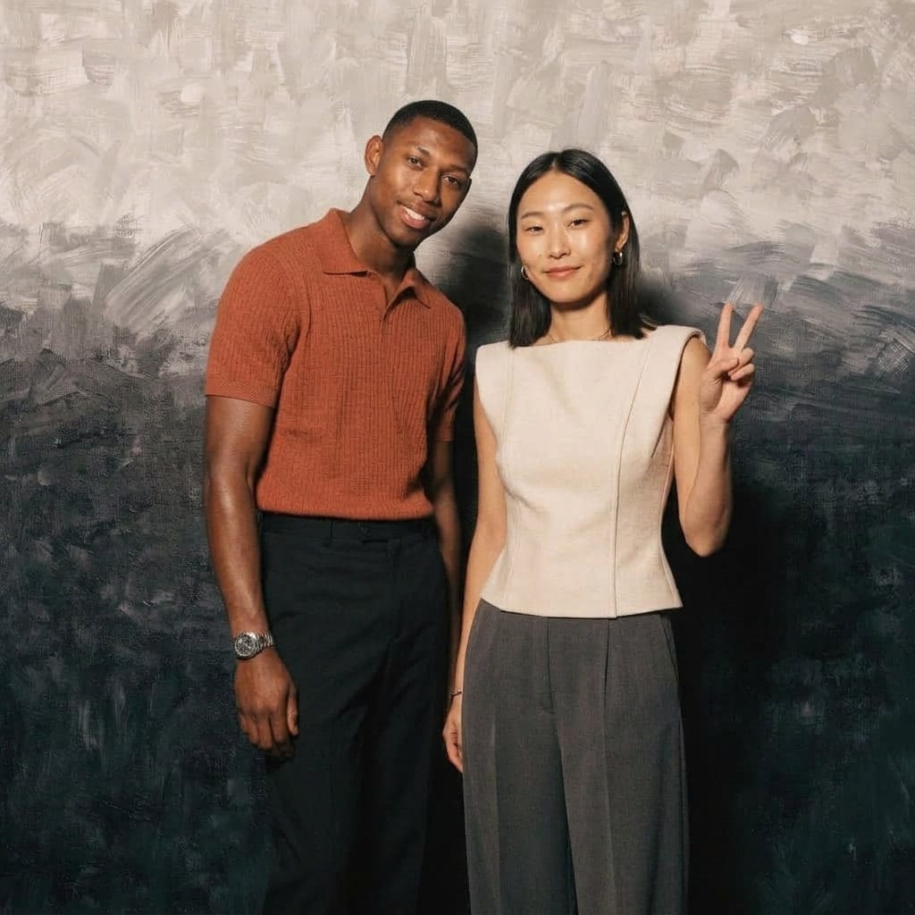 Two colleagues against a soft grey backdrop at a company event