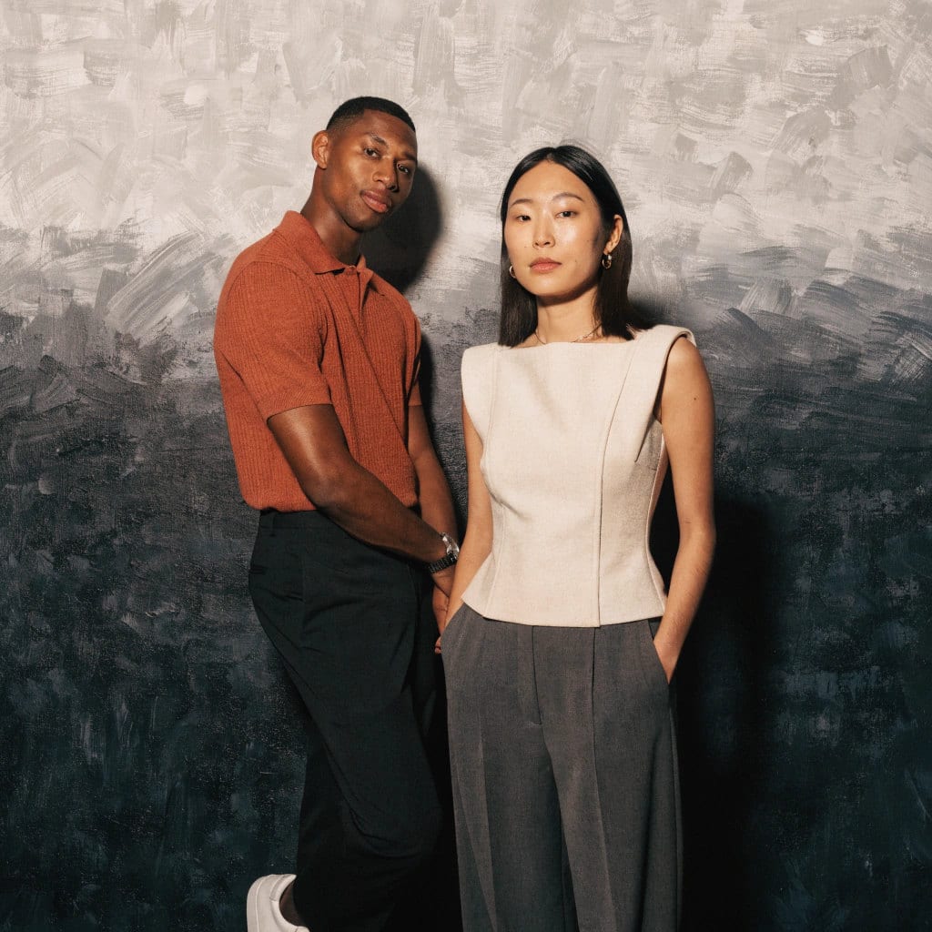 Two colleagues against a soft grey backdrop at a company event